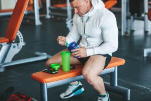 La importancia de la proteína en la dieta y cómo el whey protein puede ayudar. Hombre preparando un batido de whey protein